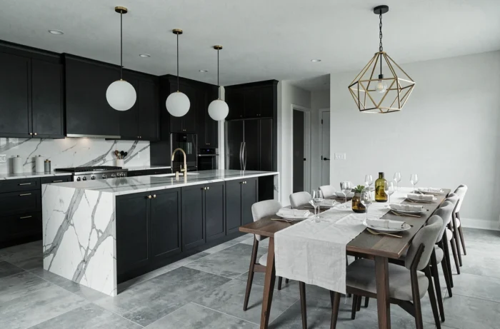 Cuisine ouverte moderne avec armoires noires matte, îlot en marbre Calacatta et quincaillerie en laiton brossé